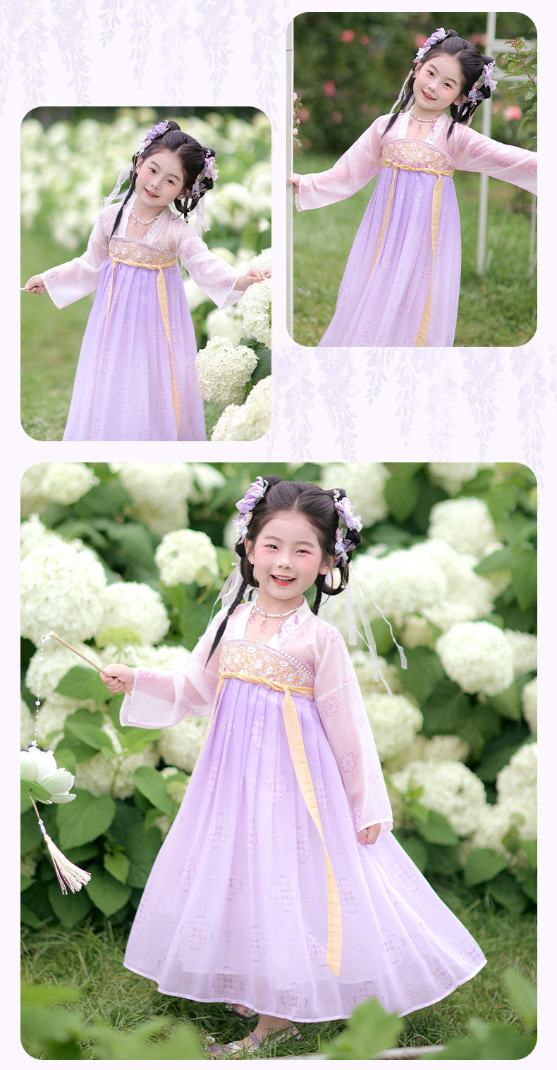 Child in a traditional outfit standing among white flowers