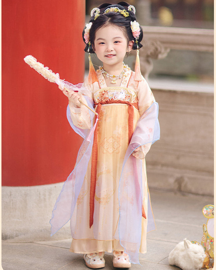 Child in traditional outfit with decorative hair accessories and a red background