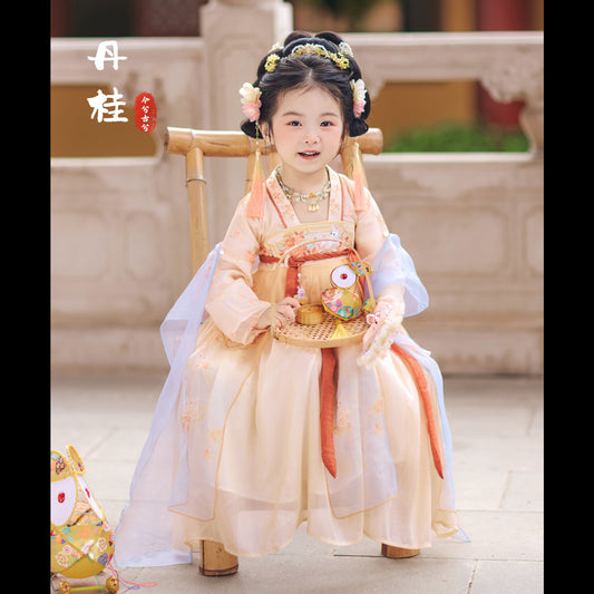 Child in traditional outfit sitting on a chair outdoors