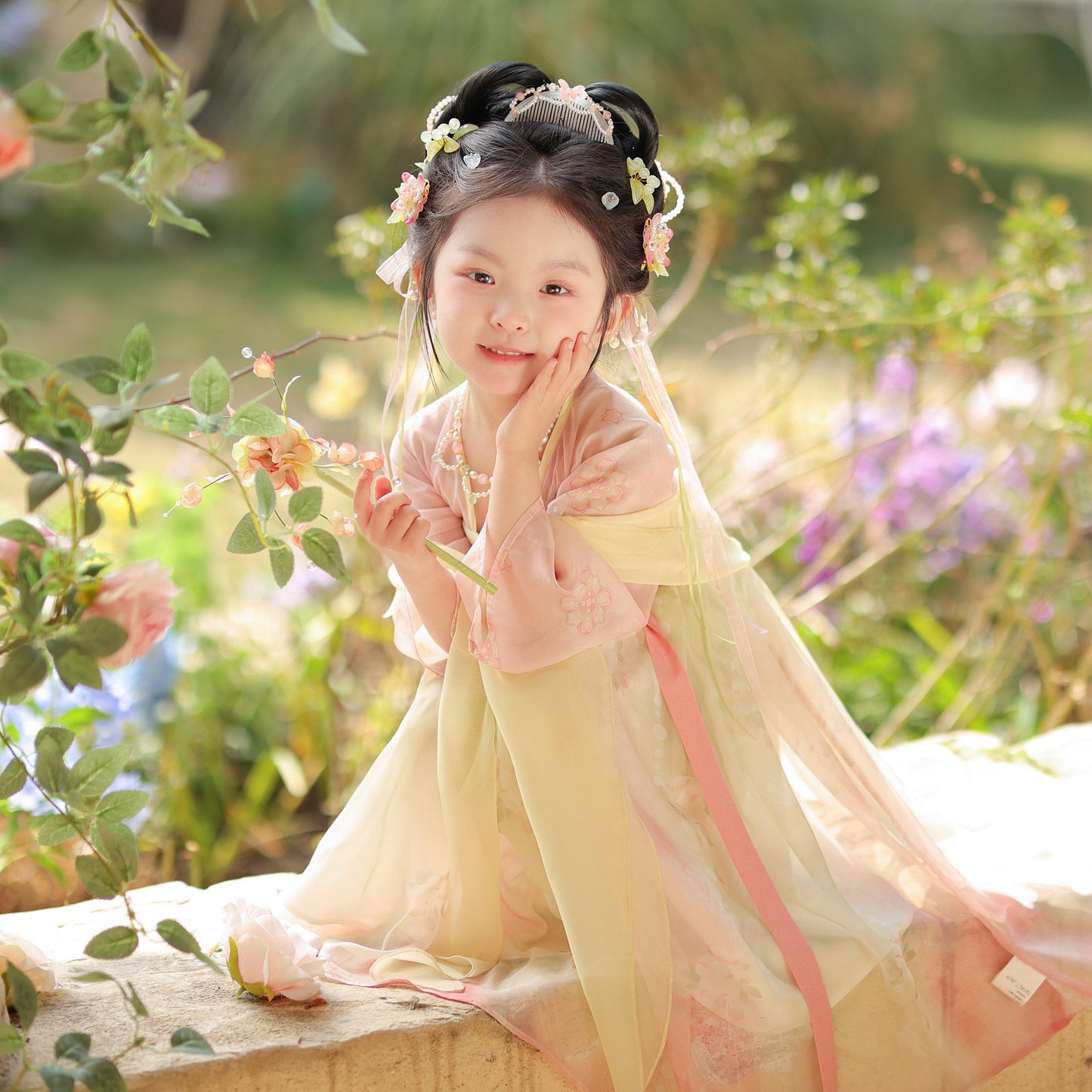 Young girl in traditional attire sitting among flowers and plants