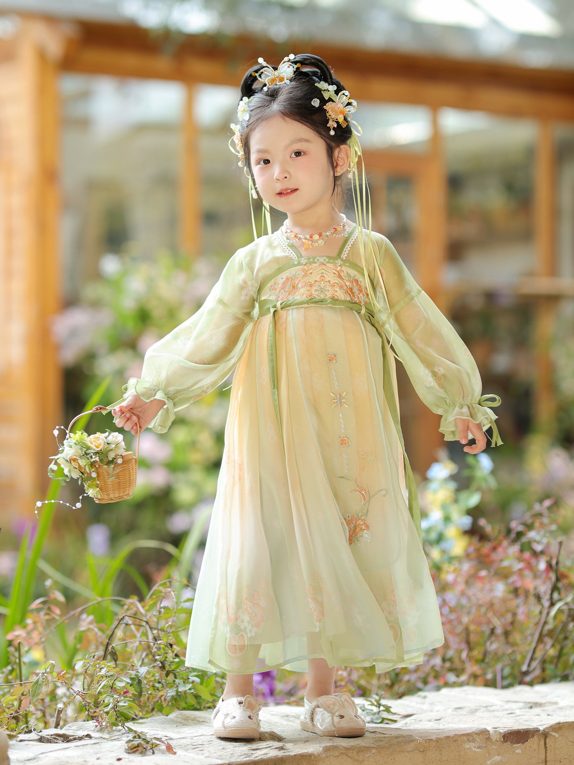 Young girl in a traditional outfit standing in a garden