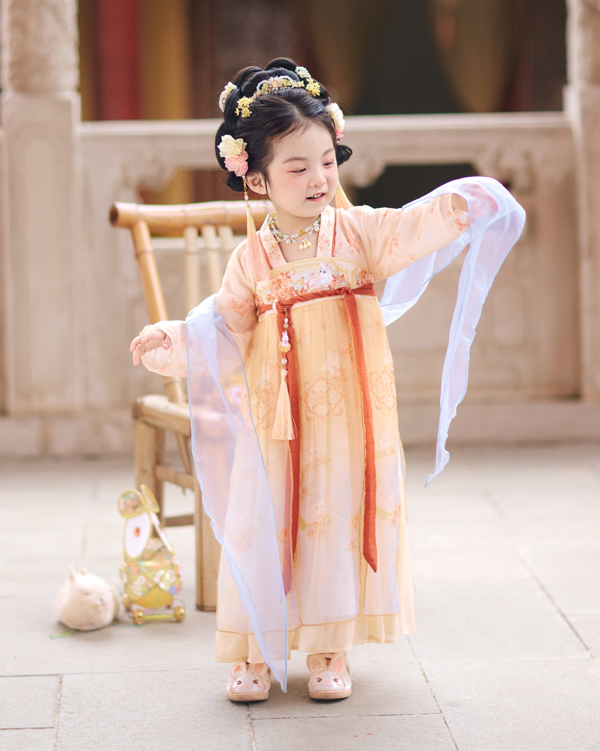 Child in traditional outfit with floral hair accessories in an indoor setting