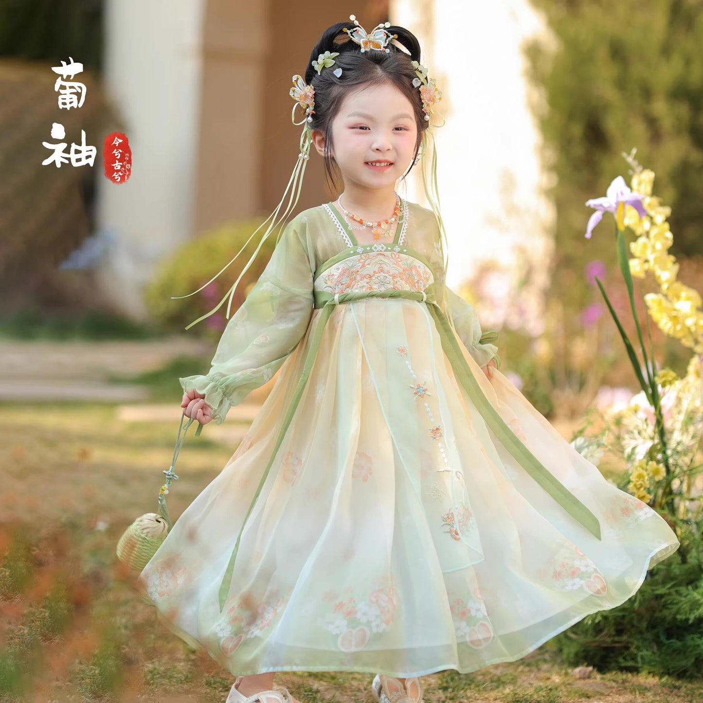 Young girl in a traditional Hanfu dress standing outdoors with blurred background