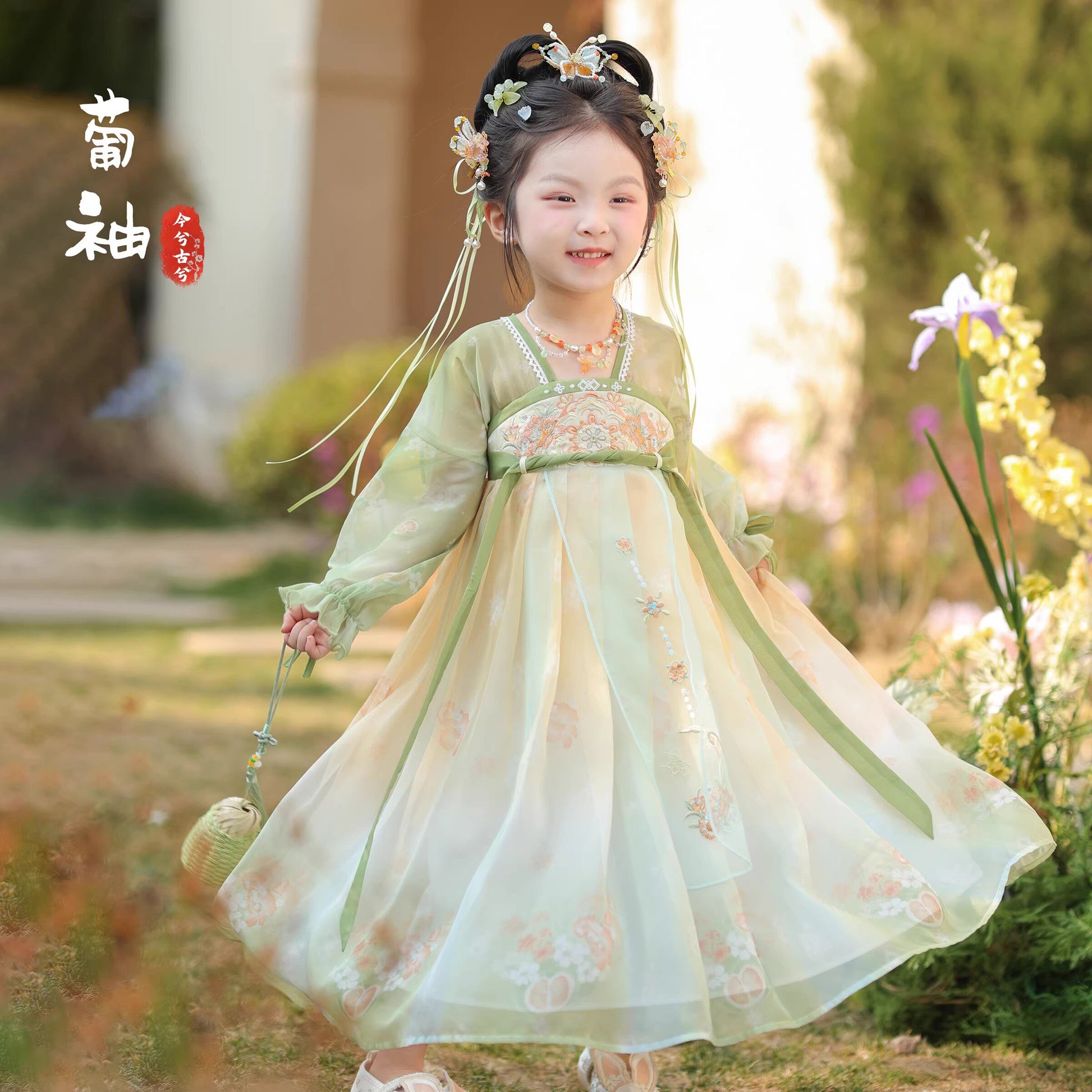 Young girl in a traditional Hanfu dress standing outdoors with blurred background
