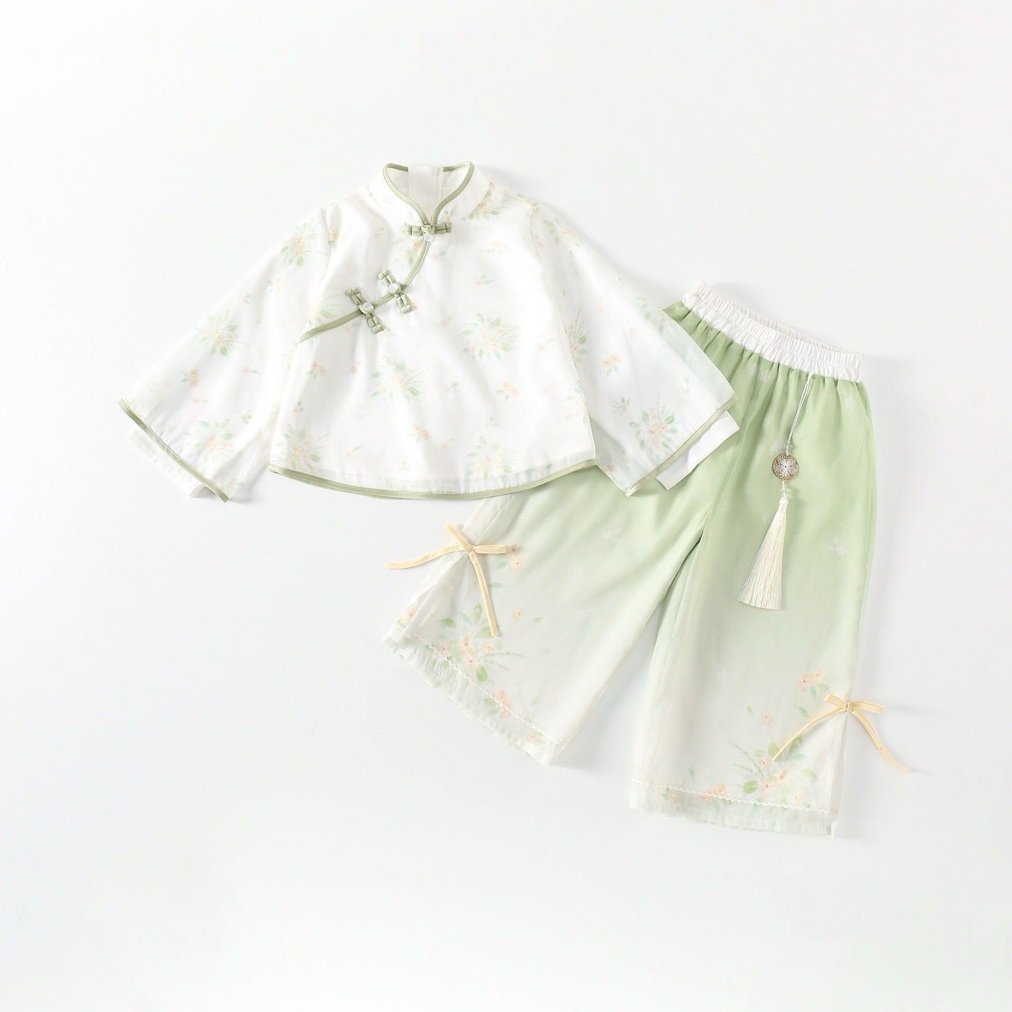 Traditional outfit with a white top and green pants on a white background