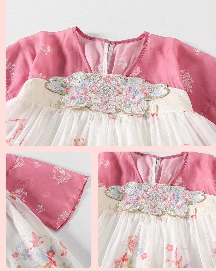 Traditional outfit with floral embroidery on a pink background