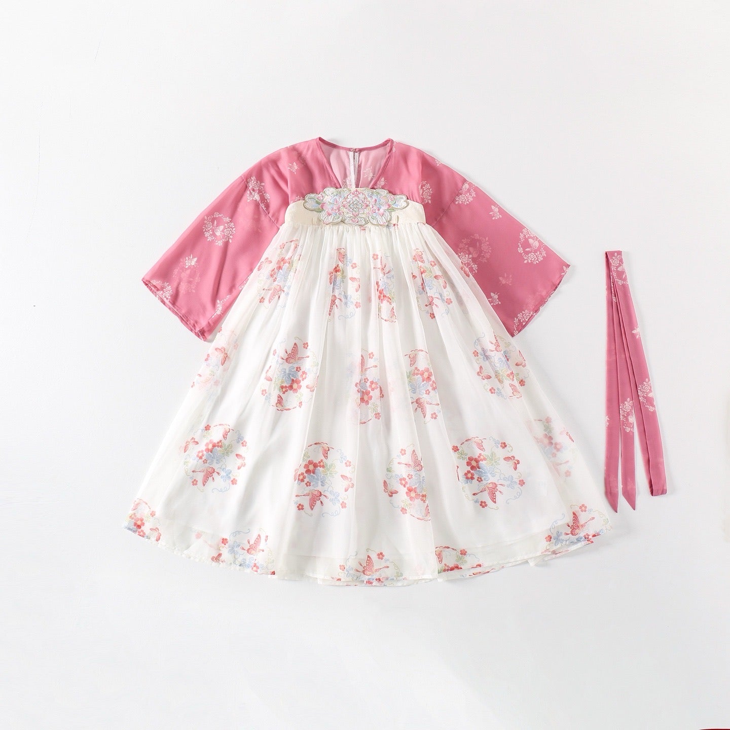 Traditional outfit with pink top and floral skirt on a white background