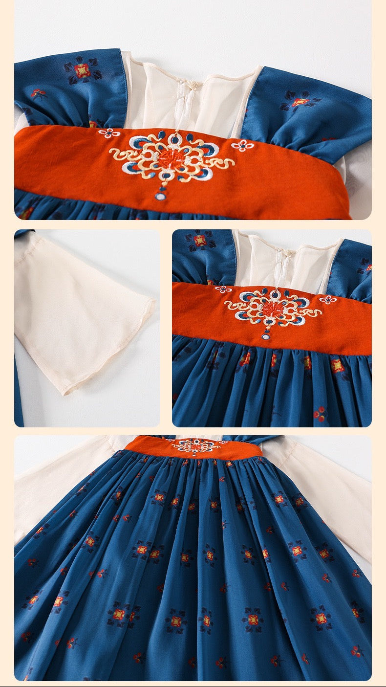 Traditional embroidered garment with blue and orange design on a white background
