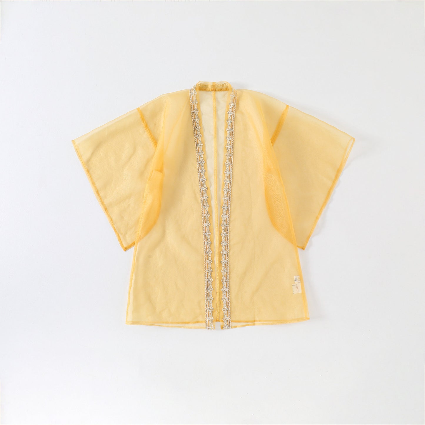 Yellow garment with decorative trim on a white background